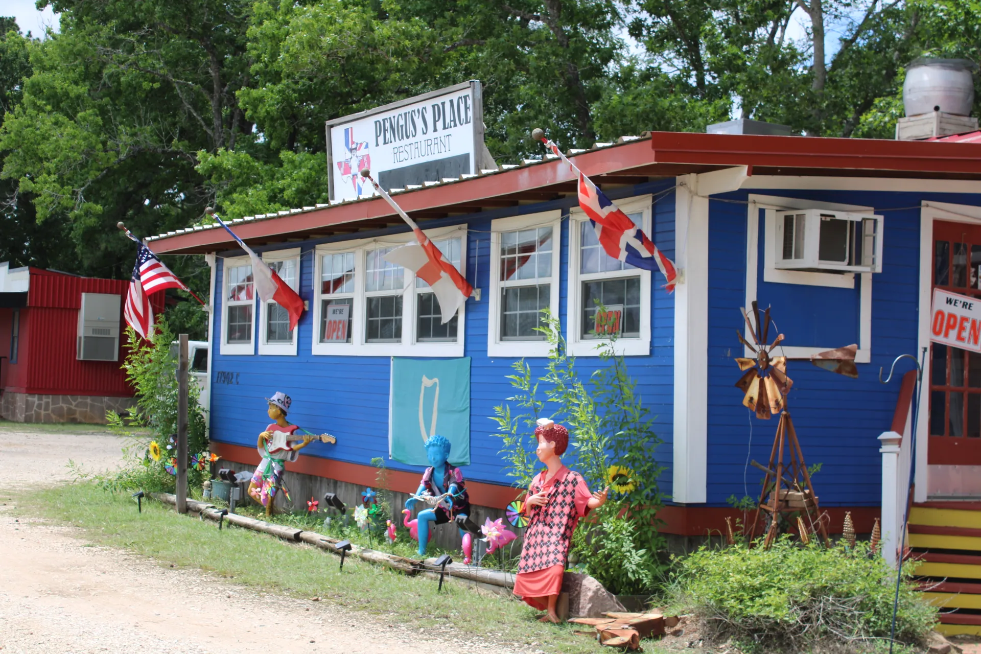 Pengus's Place — the little blue cafe in Magnolia, Texas, with British and American flags flying out front
