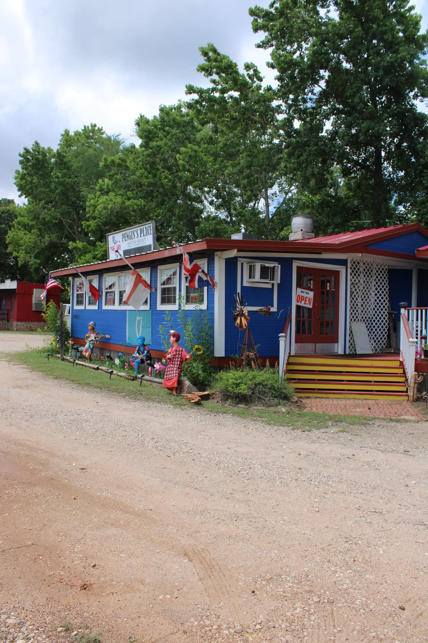 The front of Pengus's Place with British and American flags, bunting, and a cottage garden